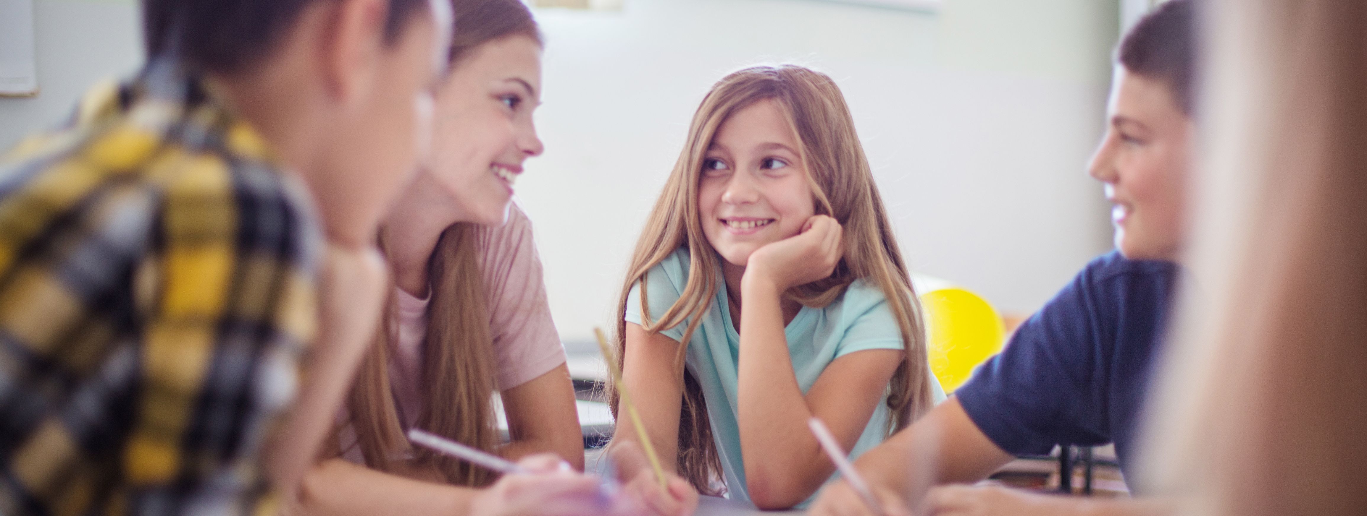 Teenagers students sitting in the classroom and talking.