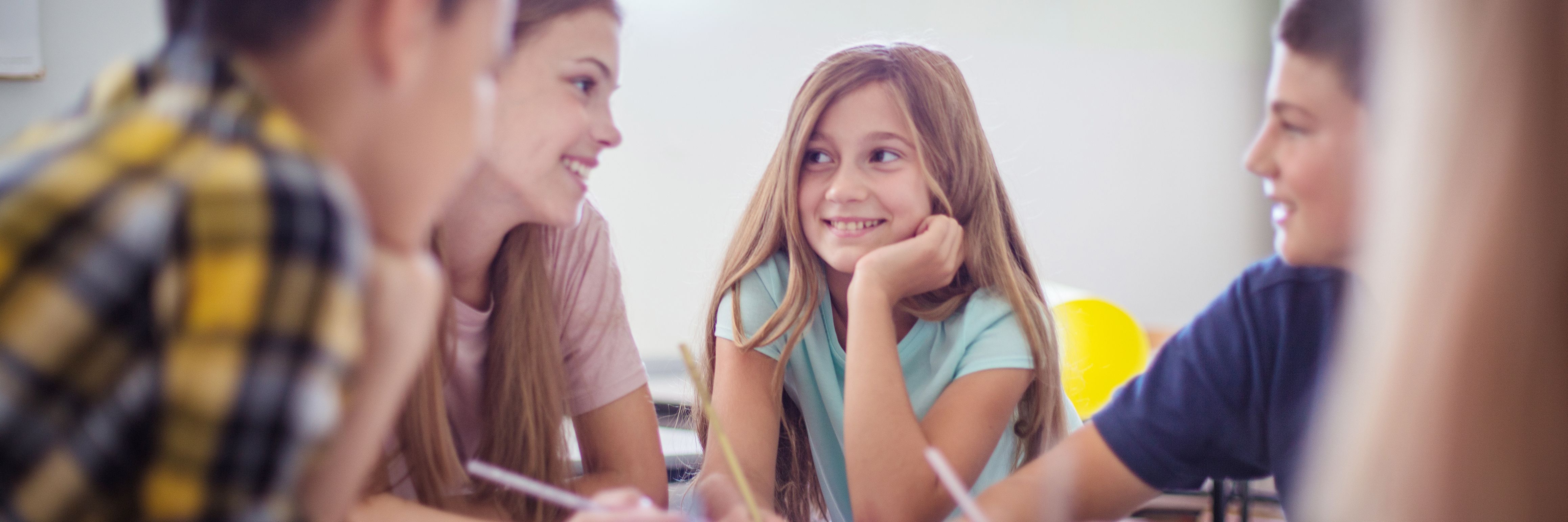 Teenagers students sitting in the classroom and talking.