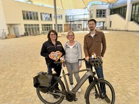 Das Orga-Team der Pfingstkirmes, hier vertreten durch Sabrina Hünnies (li.) und Manuela Schmidt, freut sich gemeinsam mit Klimaschutzmanager Thomas Tokotsch, dass die Pfingstkirmes in diesem Jahr eine große Rolle beim Stadtradeln spielt.