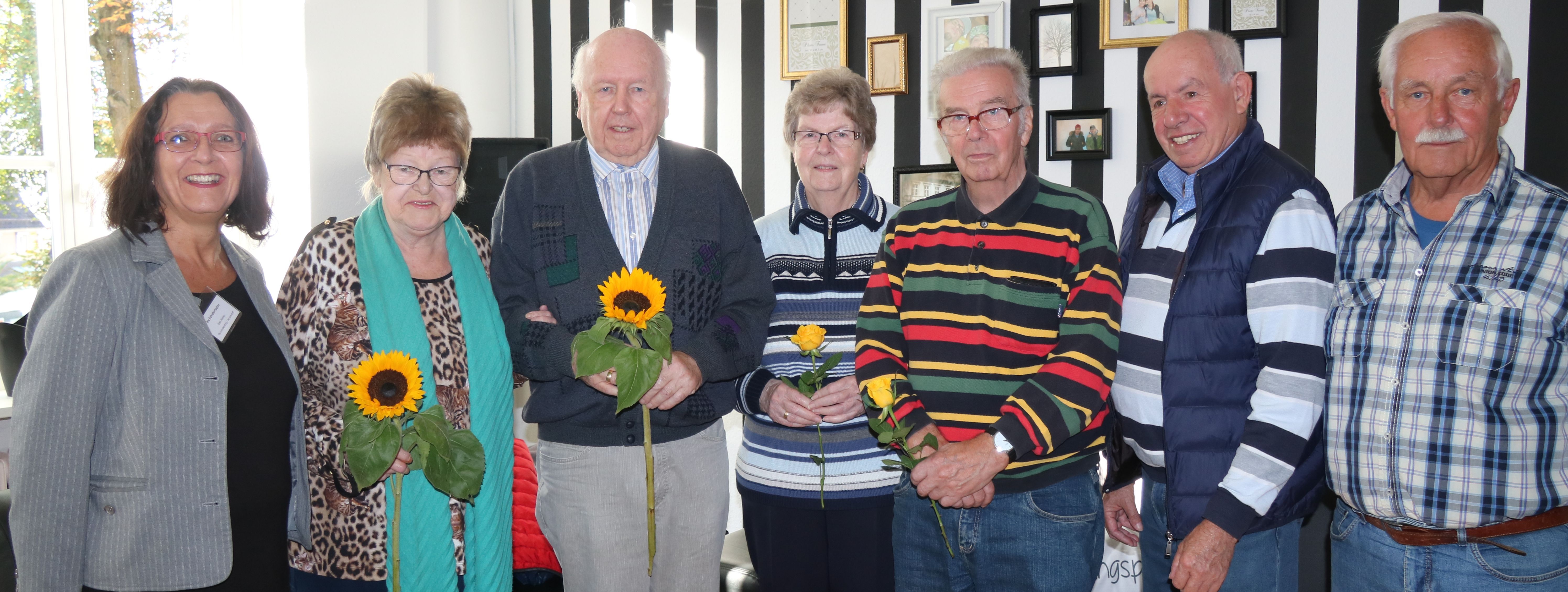 Die ehrenamtlichen Mitgleider von "Senioren Online" stehen im Halbkreis, gemeinsam mit Iris Schieferdecker vom Seniorentreff der Stadt. Die Teilnehmer halten Blumen in den Händen, die sie zum Dank erhalten haben.