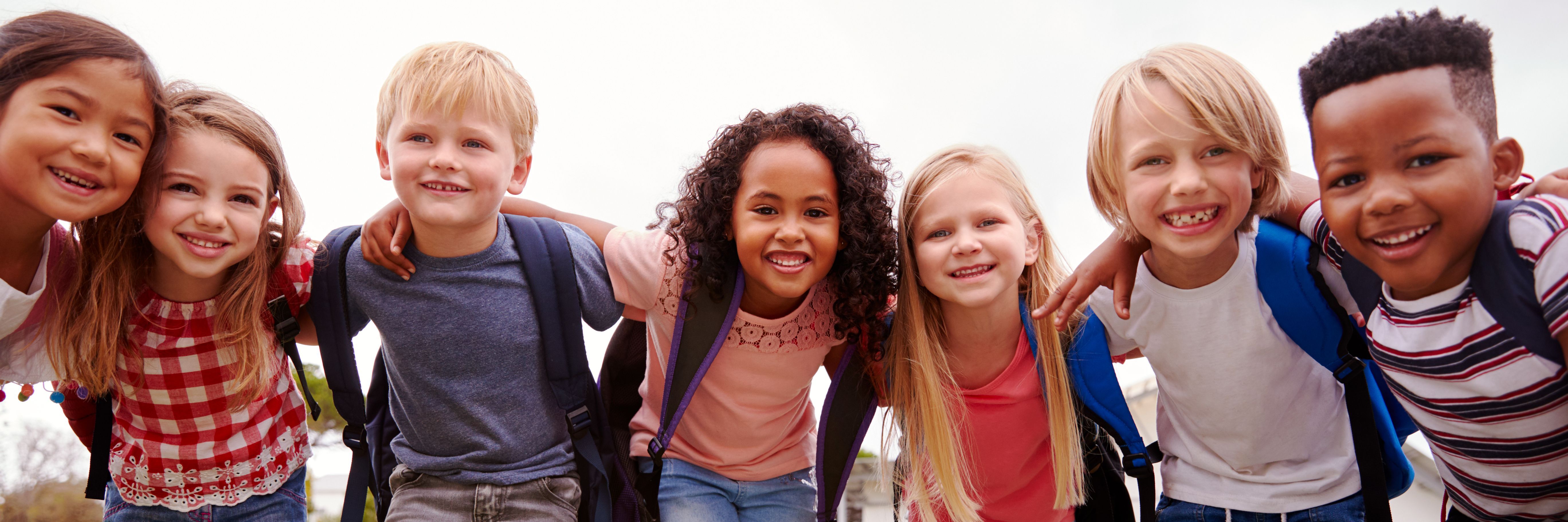 Portrait Of Excited Elementary School Pupils On Playing Field At Break Time