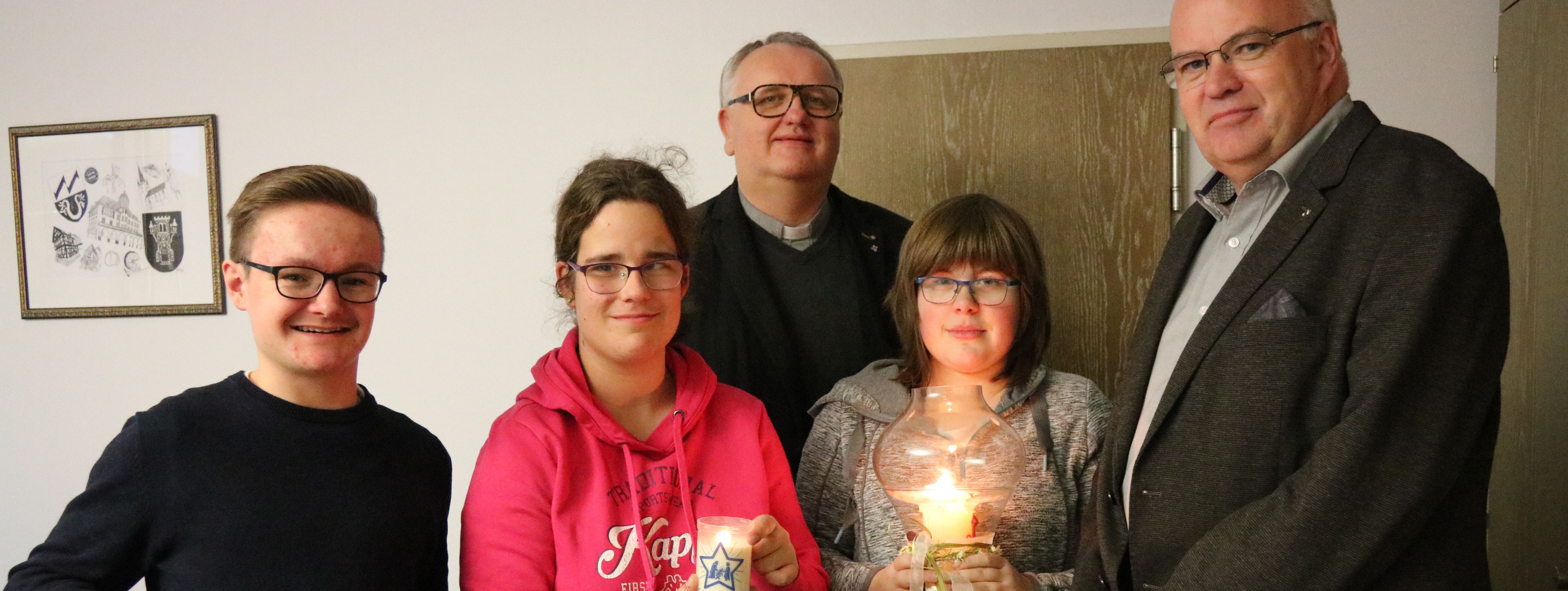 Florian Stracke, Annalena Romberg und Henrike Fiedler überreichen das Friedenslicht aus Betlehem, gemeinsam mit Pastor Uwe Knäpper an Bürgermeister Martin Wächter.