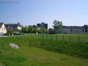 Offenes Regenrückhaltebecken in Erdbauweise im Baugebiet Pater-Kolbe-Straße. Das rd. zwei Meter tiefe Becken ist komplett mit Rasen eingewachsen, oberhalb der Böschung steht ein Zaun zur Sicherung gegen unbefugtes Betreten.