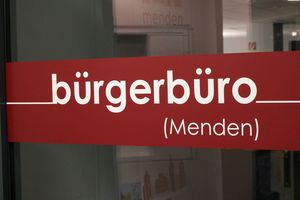 Der rote Aufkleber an der Eingangstür zum Bürgerbüro, auf dem in weißen Buchstaben das Wort "Bürgerbüro" zu lesen ist.