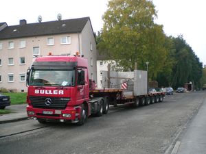 Anlieferung eines Regenüberlaufes per Tieflader. Das Bauwerk wurde in zwei Fertigteilen geliefert und vor Ort zusammengesetzt.