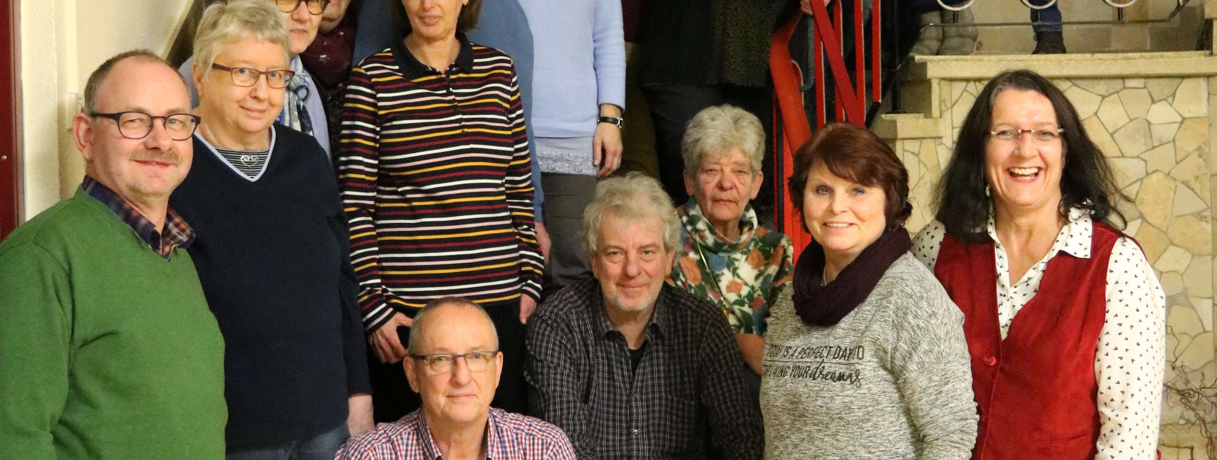 Einige Teilnehmer des Basistreffens der ZWAR-Süd Gruppe stehen auf einer Treppe