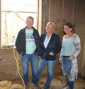 Ein Eindruck aus der Bauphase mit Lehm: Einer der Handwerker in Gut Rödinghausen gemeinsam mit Markus Majewski, Ulrike Schriever und Katharina Neuhaus vom ISM.