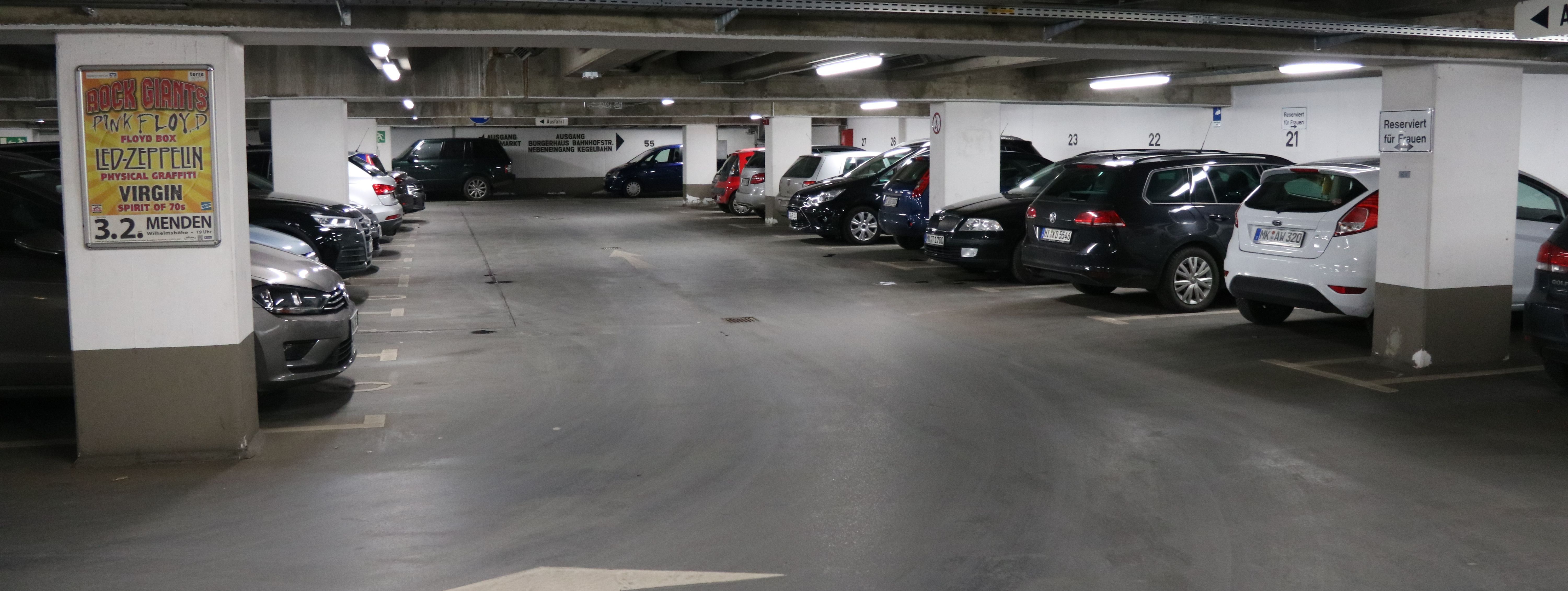 Die Tiefgarage unter dem Rathaus am Neumarkt. In mehreren Reihen parken hier Autos. Zwischen den Parkboxen sind in regelmäßigen Abständen weiße Säulen, die die Decke stützen.