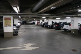 Die Tiefgarage unter dem Rathaus am Neumarkt. In mehreren Reihen parken hier Autos. Zwischen den Parkboxen sind in regelmäßigen Abständen weiße Säulen, die die Decke stützen.