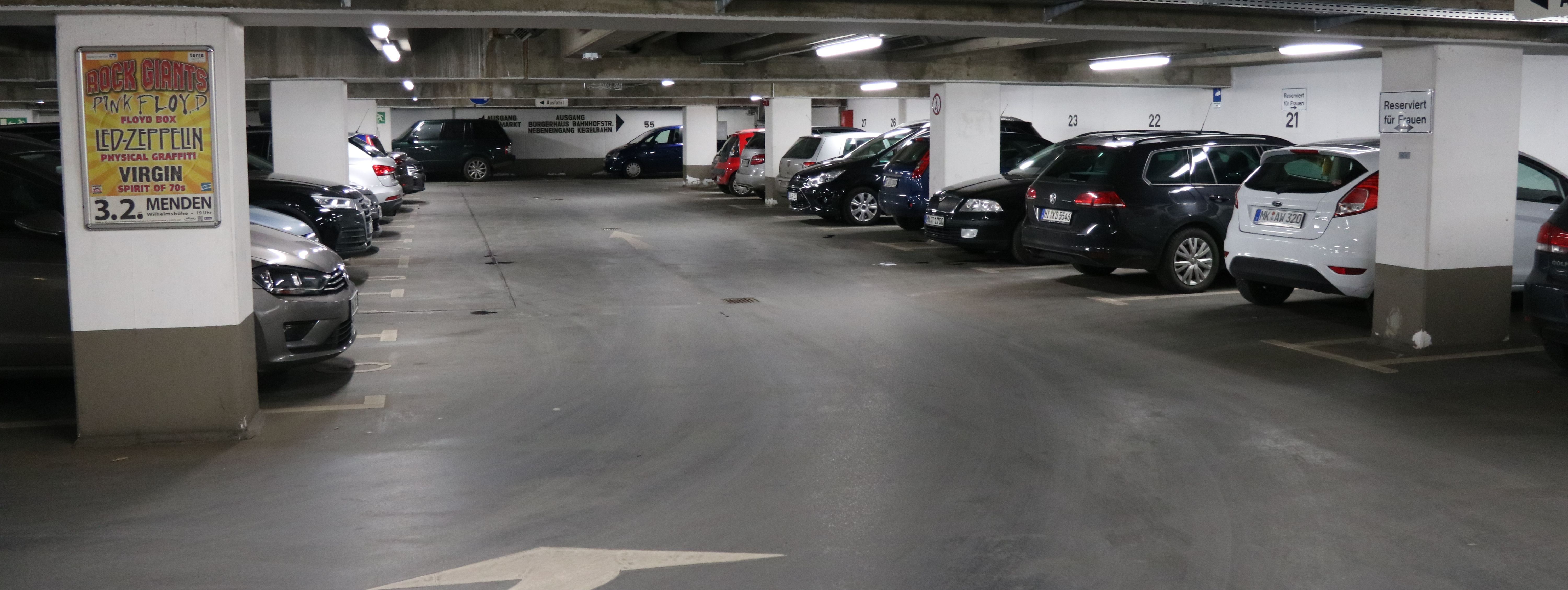 Die Tiefgarage unter dem Rathaus am Neumarkt. In mehreren Reihen parken hier Autos. Zwischen den Parkboxen sind in regelmäßigen Abständen weiße Säulen, die die Decke stützen.