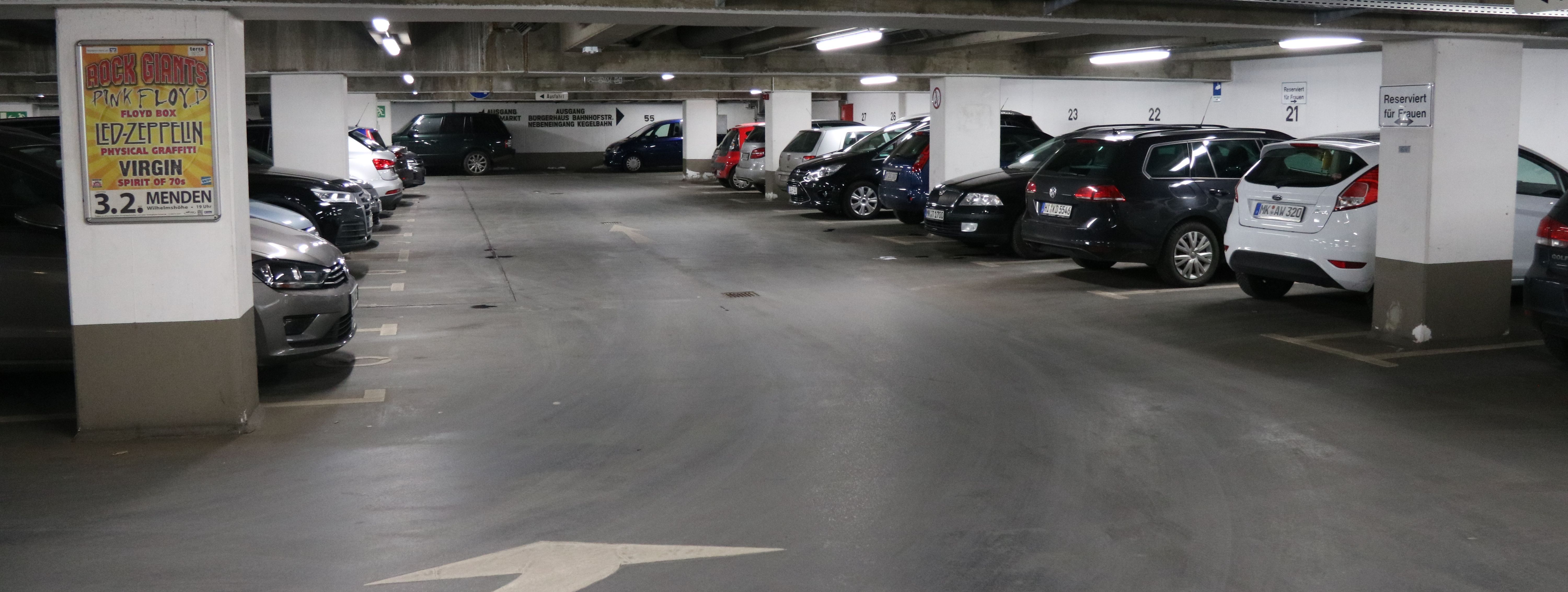 Die Tiefgarage unter dem Rathaus am Neumarkt. In mehreren Reihen parken hier Autos. Zwischen den Parkboxen sind in regelmäßigen Abständen weiße Säulen, die die Decke stützen.