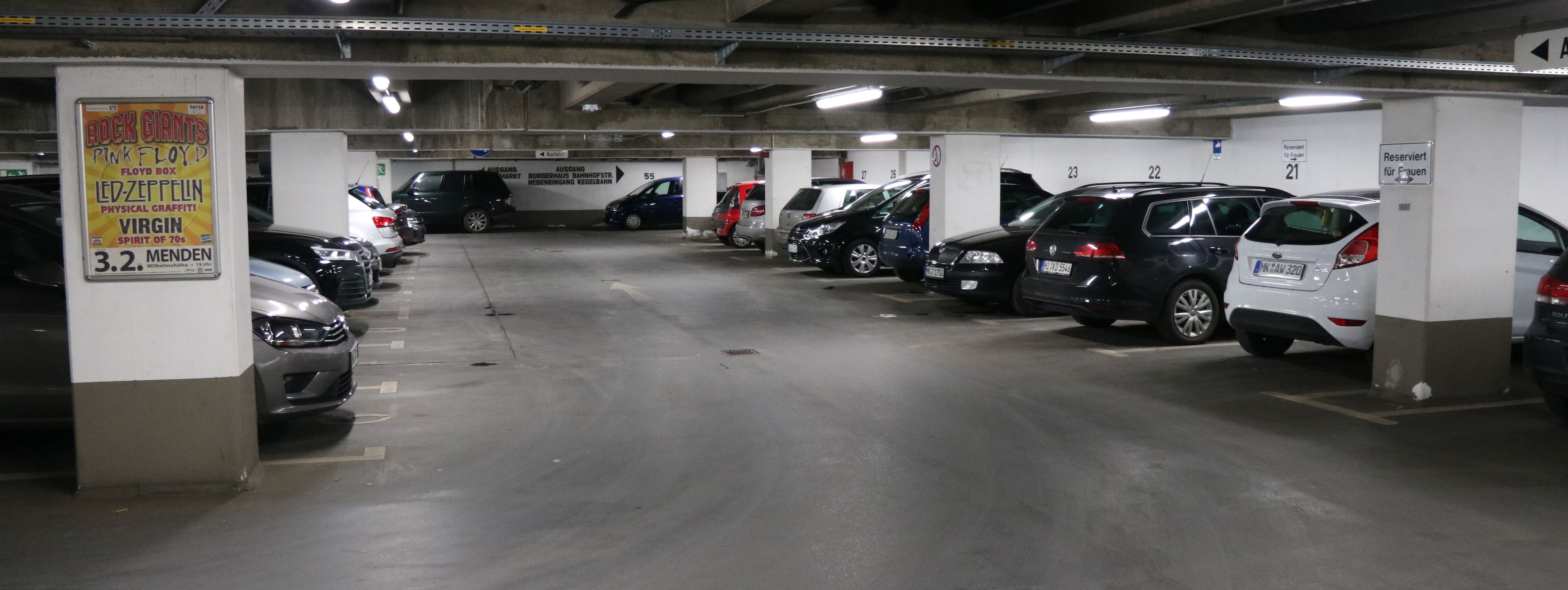 Die Tiefgarage unter dem Rathaus am Neumarkt. In mehreren Reihen parken hier Autos. Zwischen den Parkboxen sind in regelmäßigen Abständen weiße Säulen, die die Decke stützen.