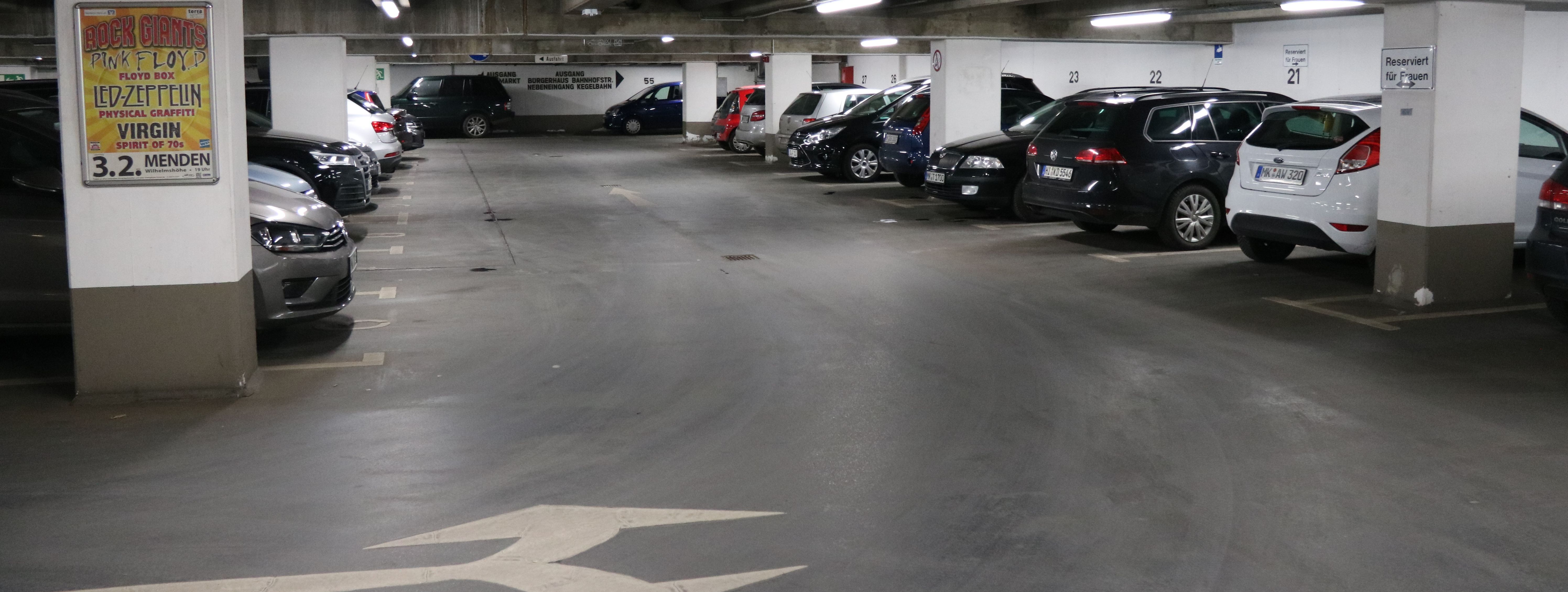 Die Tiefgarage unter dem Rathaus am Neumarkt. In mehreren Reihen parken hier Autos. Zwischen den Parkboxen sind in regelmäßigen Abständen weiße Säulen, die die Decke stützen.