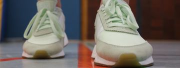 Ein paar Füße in Turnschuhen auf dem Boden einer Turnhallte