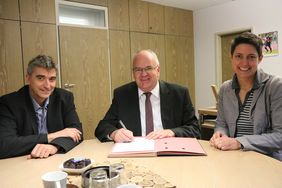 Bürgermeister Martin Wächter unterschreibt den Kooperationsvertrag mit der Berufskolleg. Mit am Tisch sitzen Jugendamtsleiter Christian-Peter Goebels (links) und Ausbildungsleiterin Sandra Krause (rechts).