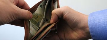 Zwei Hände öffnen ein Portemonnaie.