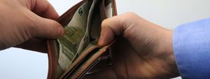 Zwei Hände öffnen ein Portemonnaie.