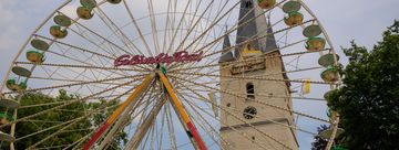 Vor dem Turm von St. Vincenz ist ein Riesenrad aufgebaut - das heimliche Wahrzeichen der Mendener Pfingskirmes