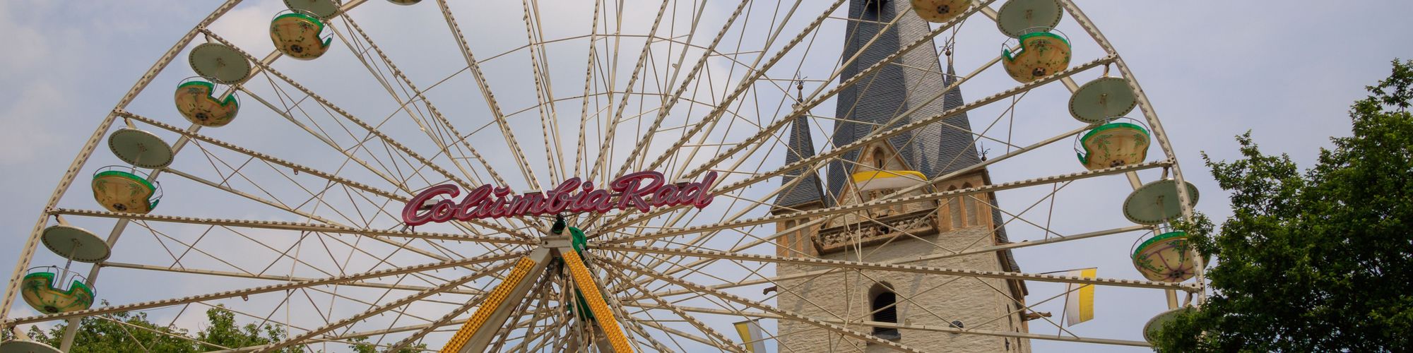 Vor dem Turm von St. Vincenz ist ein Riesenrad aufgebaut - das heimliche Wahrzeichen der Mendener Pfingskirmes