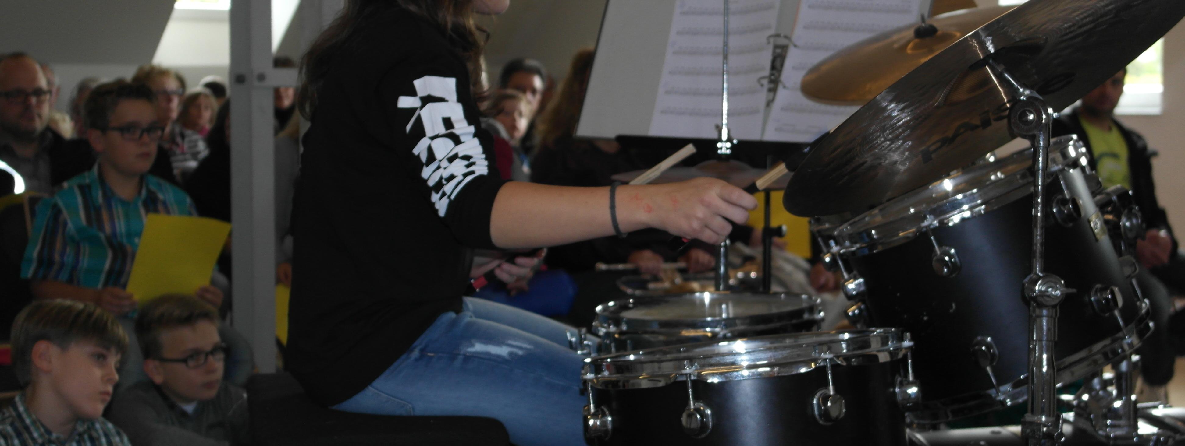 Ein Schüler der Musikschule spielt auf einem Schlagzeug im Westflügel der Schule