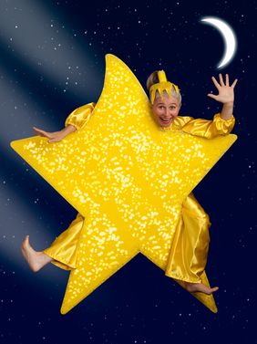 Ein großer goldener Stern, der das Kostüm der Schauspielerin bildet, die an dem obersten Zacken des Sterns vorbei schaut.