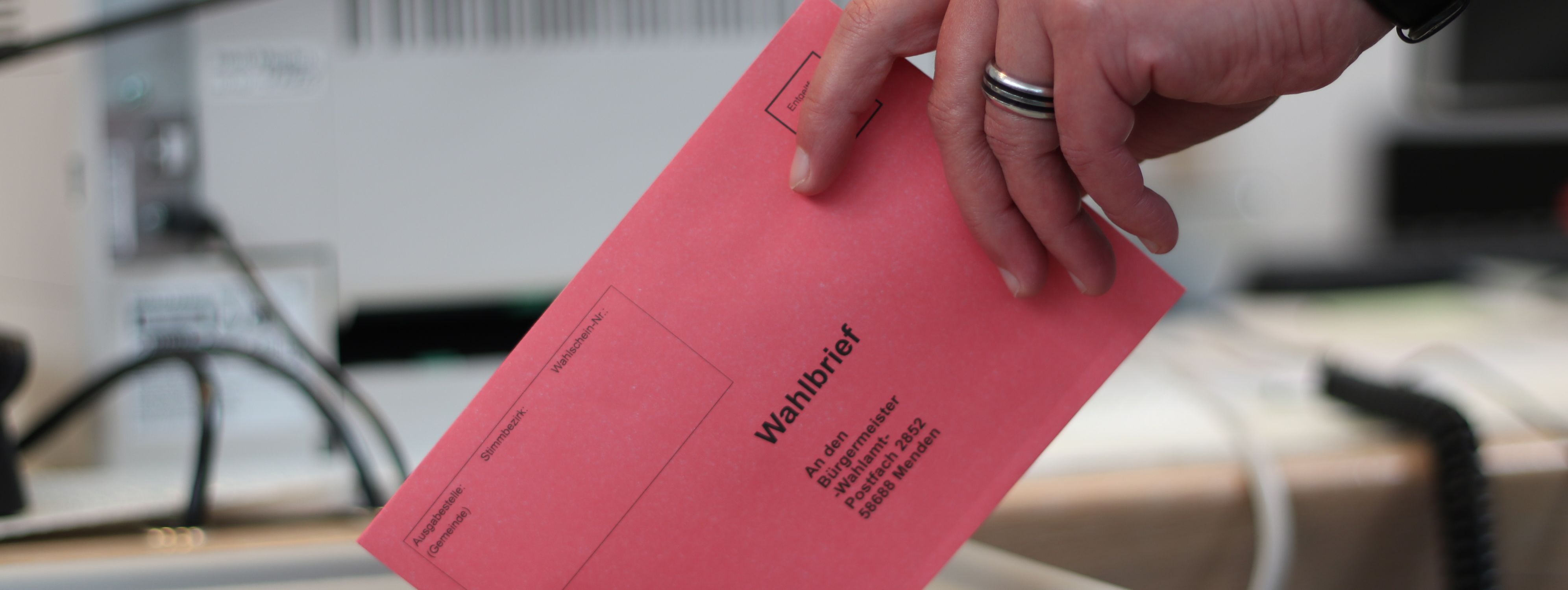 Ein roter Umschlag wird in die Wahlurne geworfen