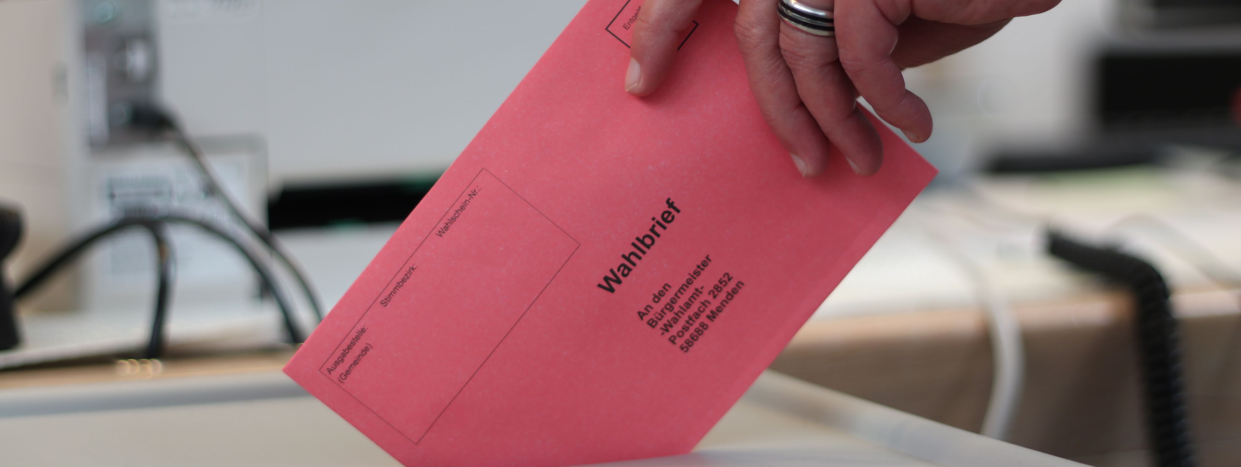 Ein roter Umschlag wird in die Wahlurne geworfen