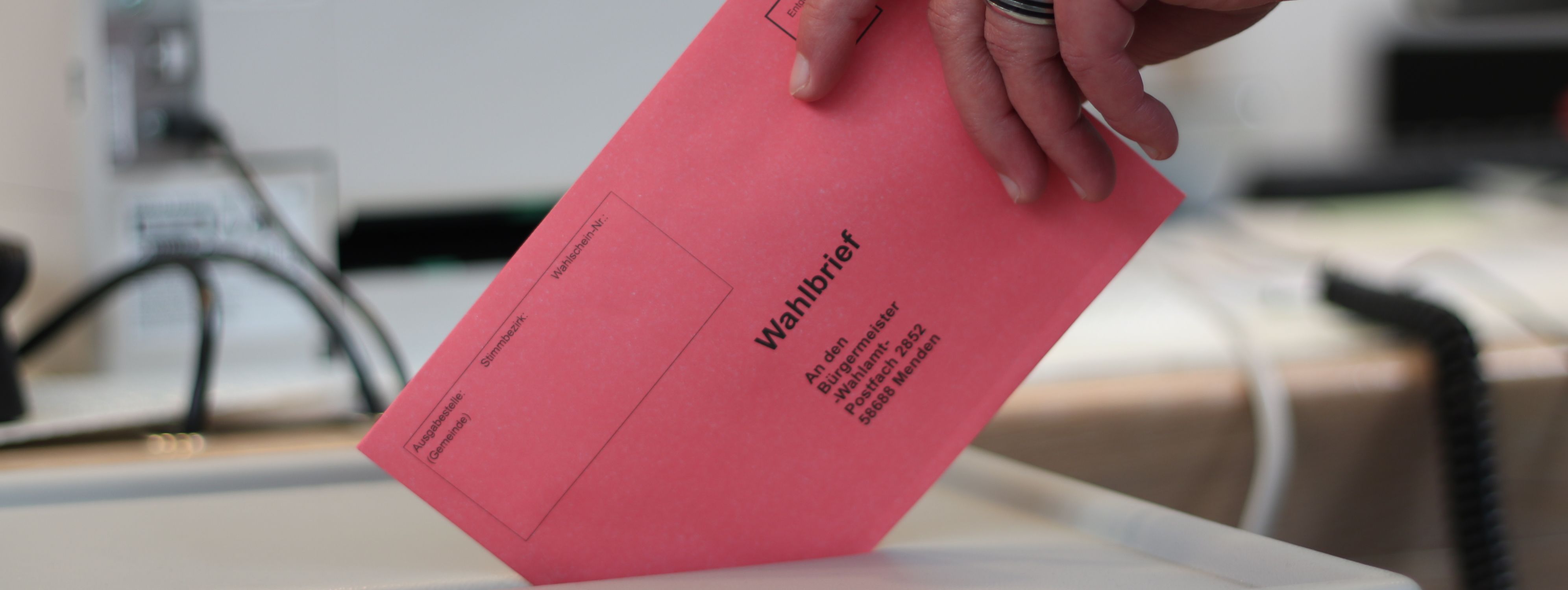 Ein roter Umschlag wird in die Wahlurne geworfen