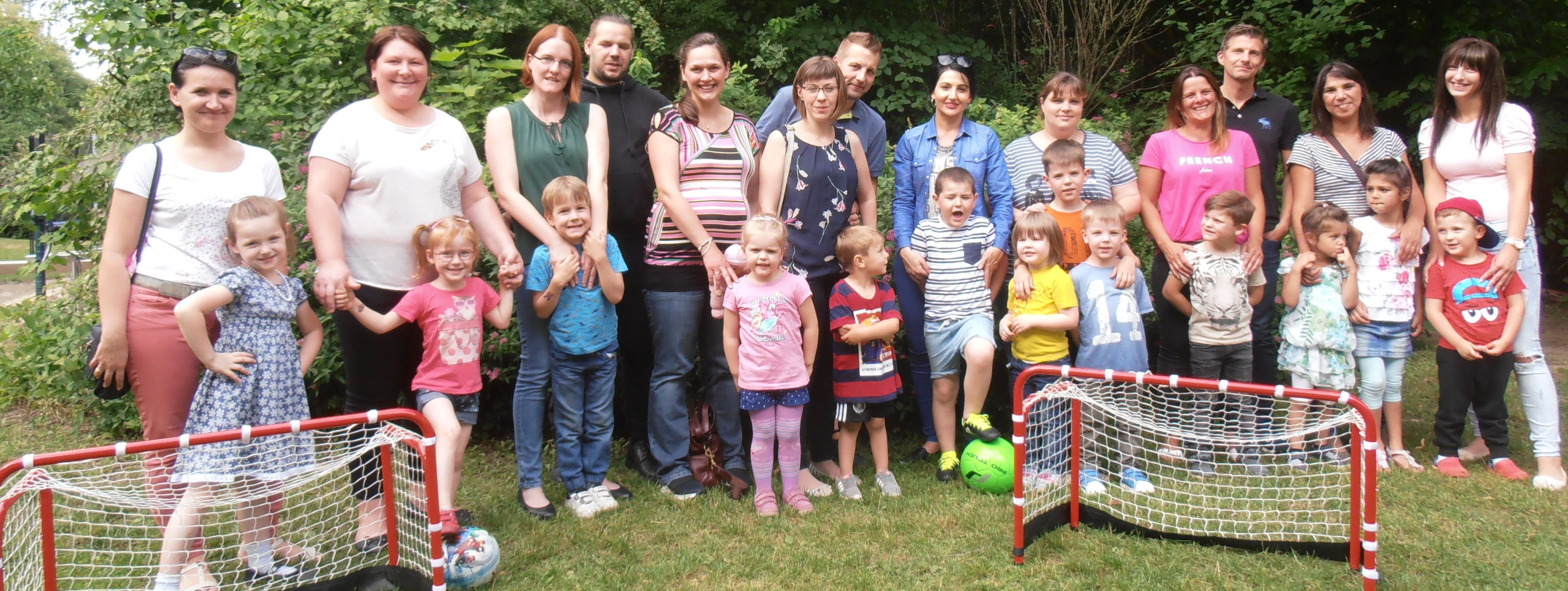 hinter zwei kleinen Fußballtoren stehen die Kita-Kinder gemeinsam mit Ihren Eltern