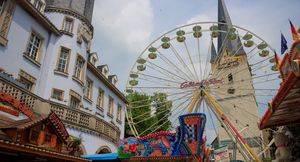Das große Riesenrad und die bunten Stände der Schausteller vor dem Alten Rathaus und dem Turm von St. Vincenz.
