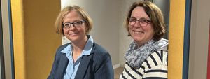 Bürgermeisterin Manuela Schmidt und die stellvertretende Büchereileiterin Sabine Hildebrand sitzen in einer der Sitzecken des neuen Bücherregals