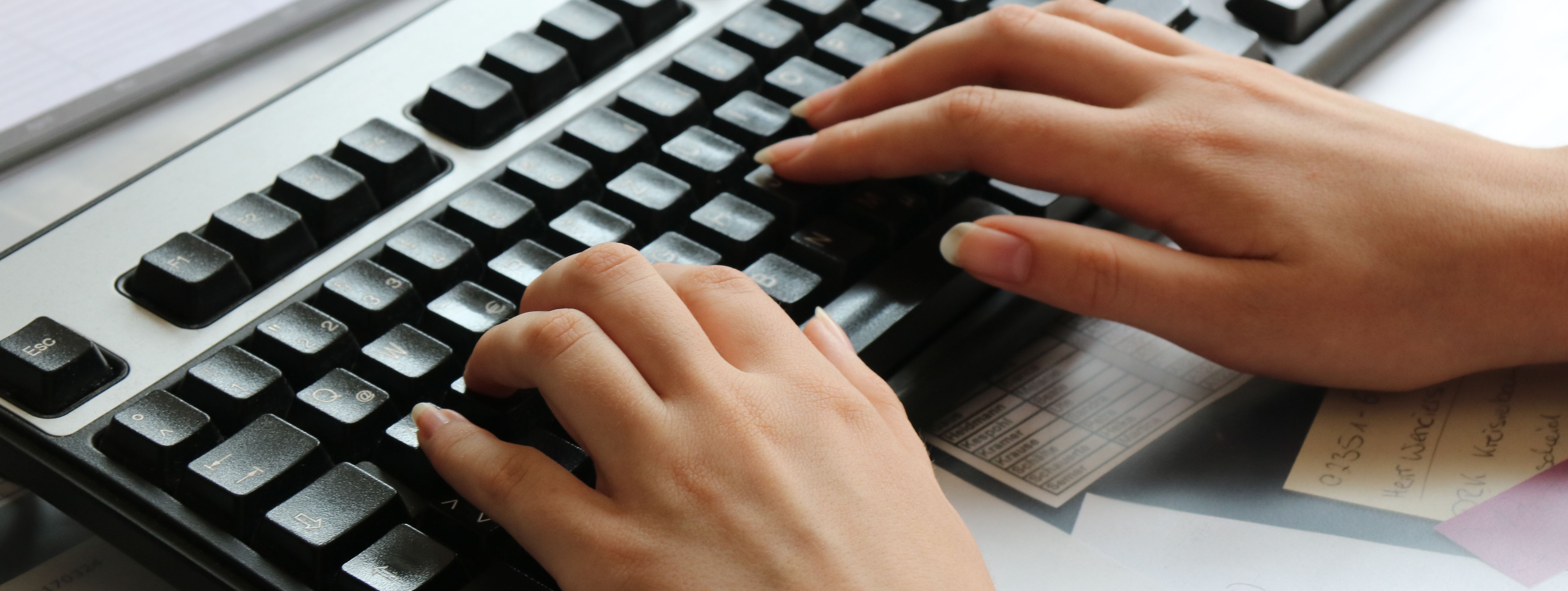 Zwei Hände tippen auf einer Computertastatur