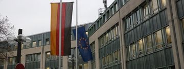 Vor dem neuen Rathaus wehen die Flaggen auf Halbmast.