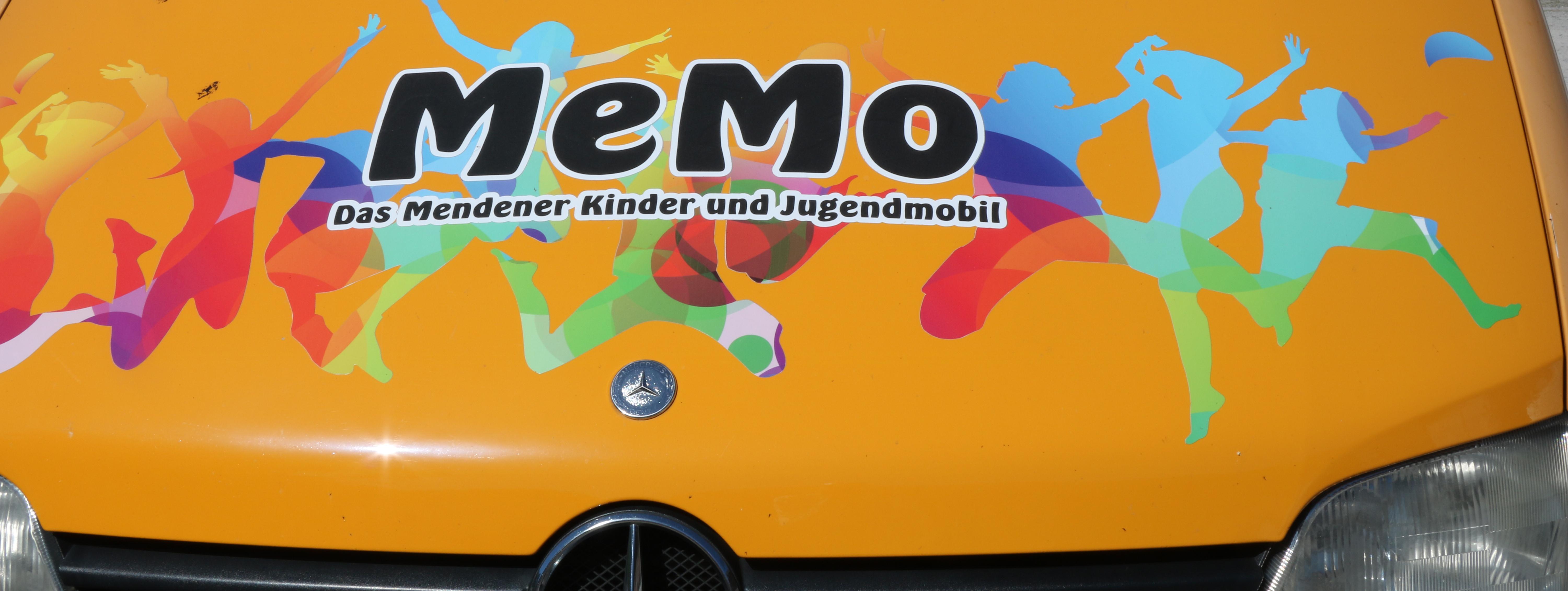 Das MEMO ist ein großer gelber Mercedes Sprinter. Auf dem Bus sind die Logos der Stadtteiltreffs und bunte Silhouetten von tanzenden Menschen geklebt worden.