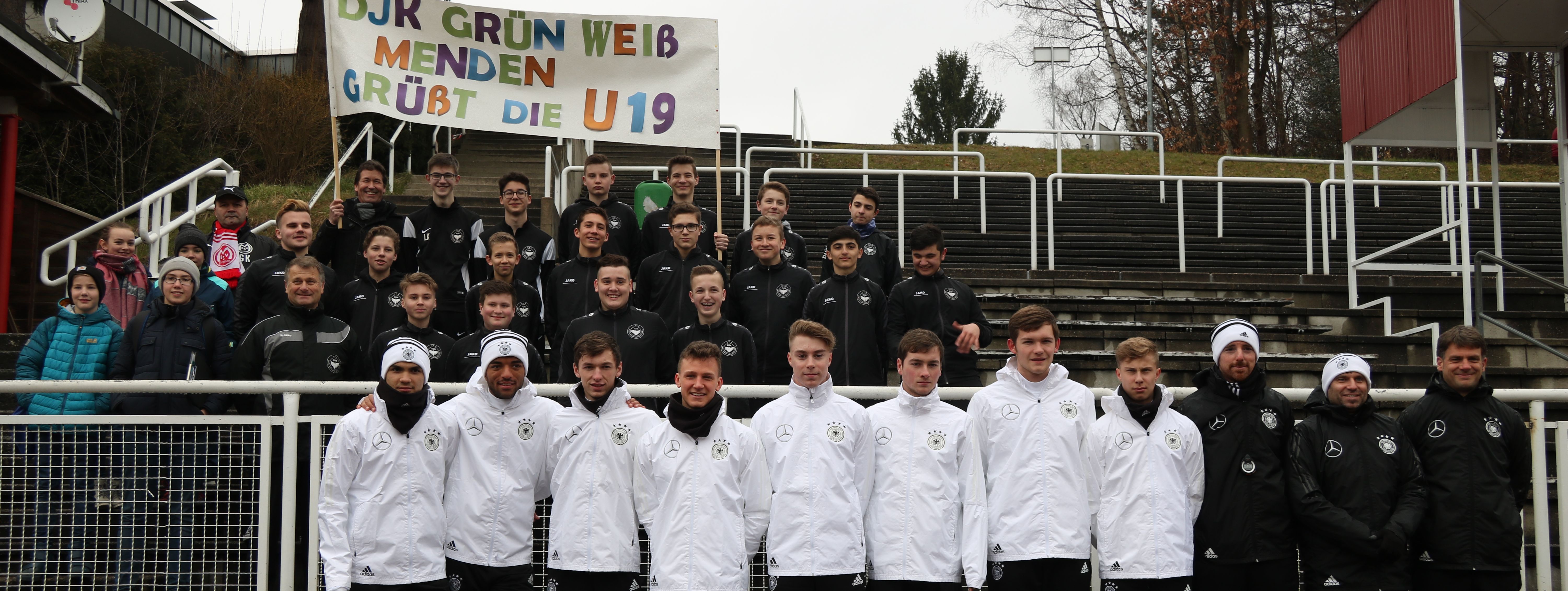 Gruppenfoto: Spieler der DFB U19 Nationalmannschaft stehen unter anderem zusammen mit Jugendlichen des DJK Bösperde auf den Stufen des Huckenohl Stadions.