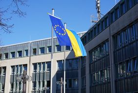 Vor dem Neuen Rathaus wehen die Flagge der Ukraine (blau/gelb) und die Europaflagge (goldene Sterne auf blauem Grund)