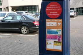 Auf dem blauen Parkscheinautomaten ist ein Aufkleber zu sehen, der das Handyparken erklärt.