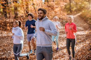 Small group of people running in woods.