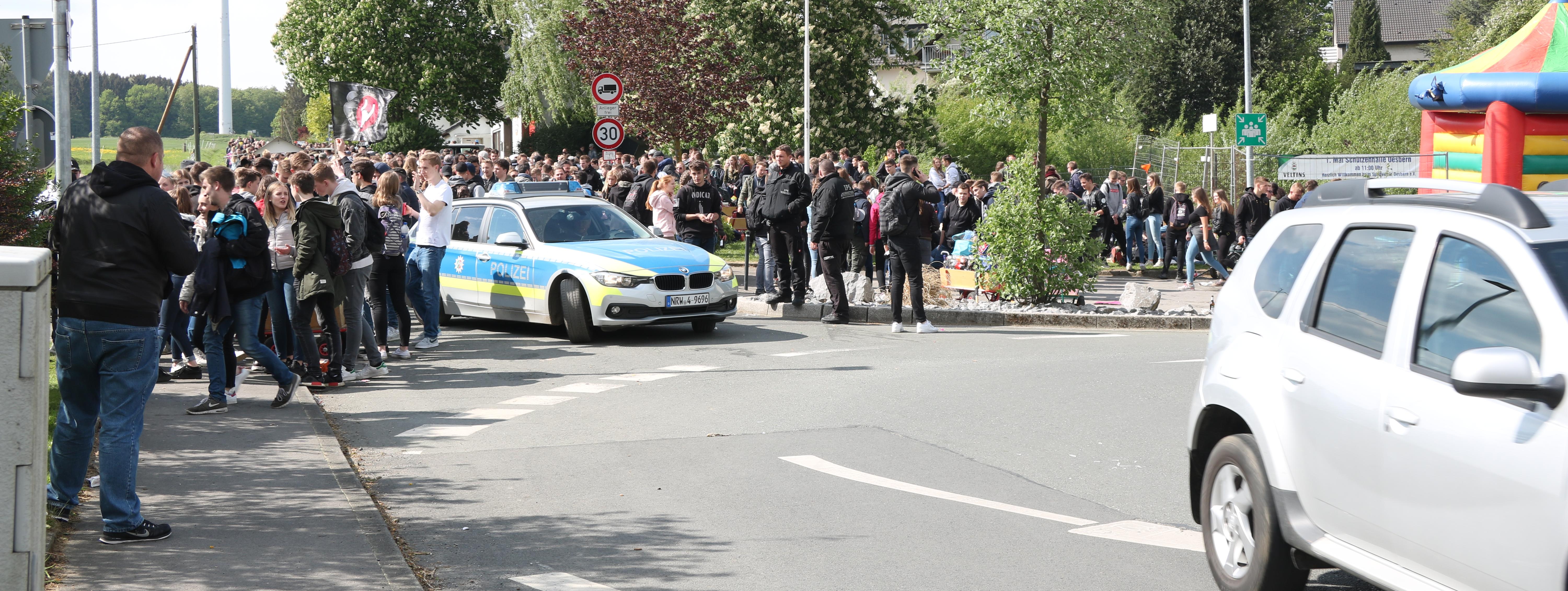 hunderte Jugendliche habe sich am Kreisverkehr in Oesbern versammelt und feiern den ersten Mai. In Mitten der Gruppe steht ein Polizeiauto.