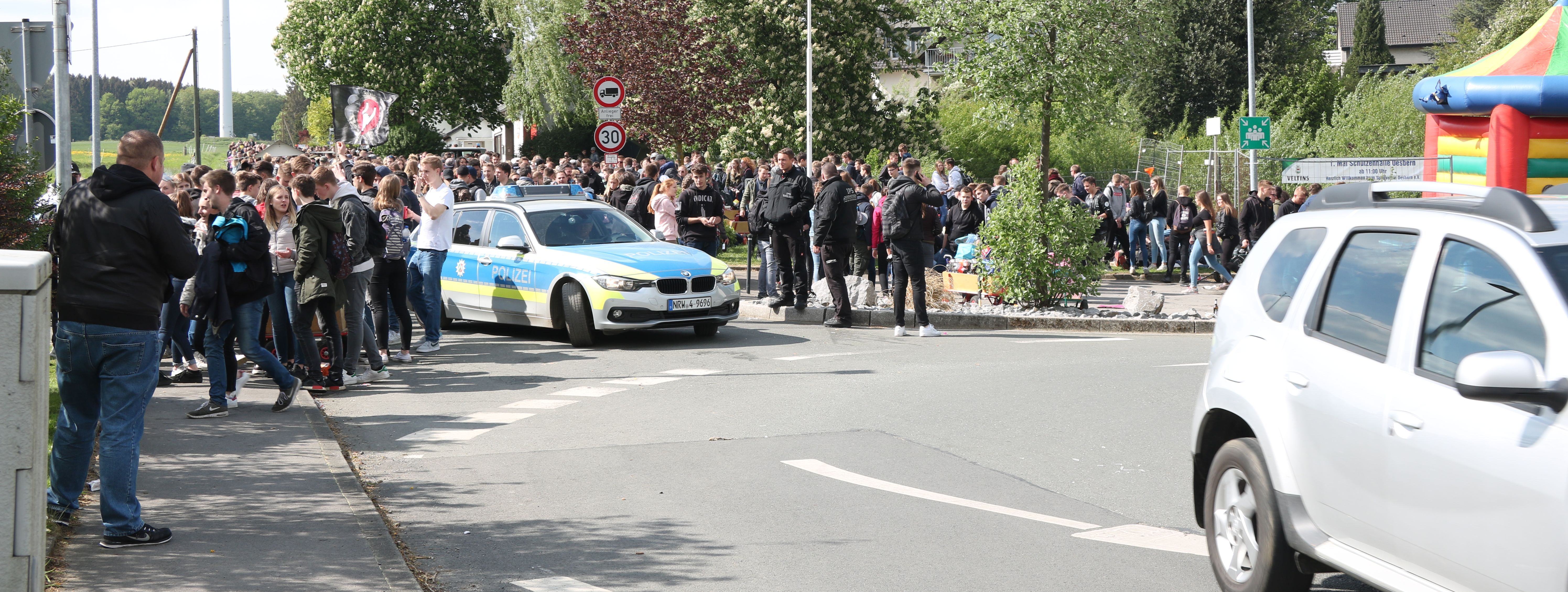 hunderte Jugendliche habe sich am Kreisverkehr in Oesbern versammelt und feiern den ersten Mai. In Mitten der Gruppe steht ein Polizeiauto.