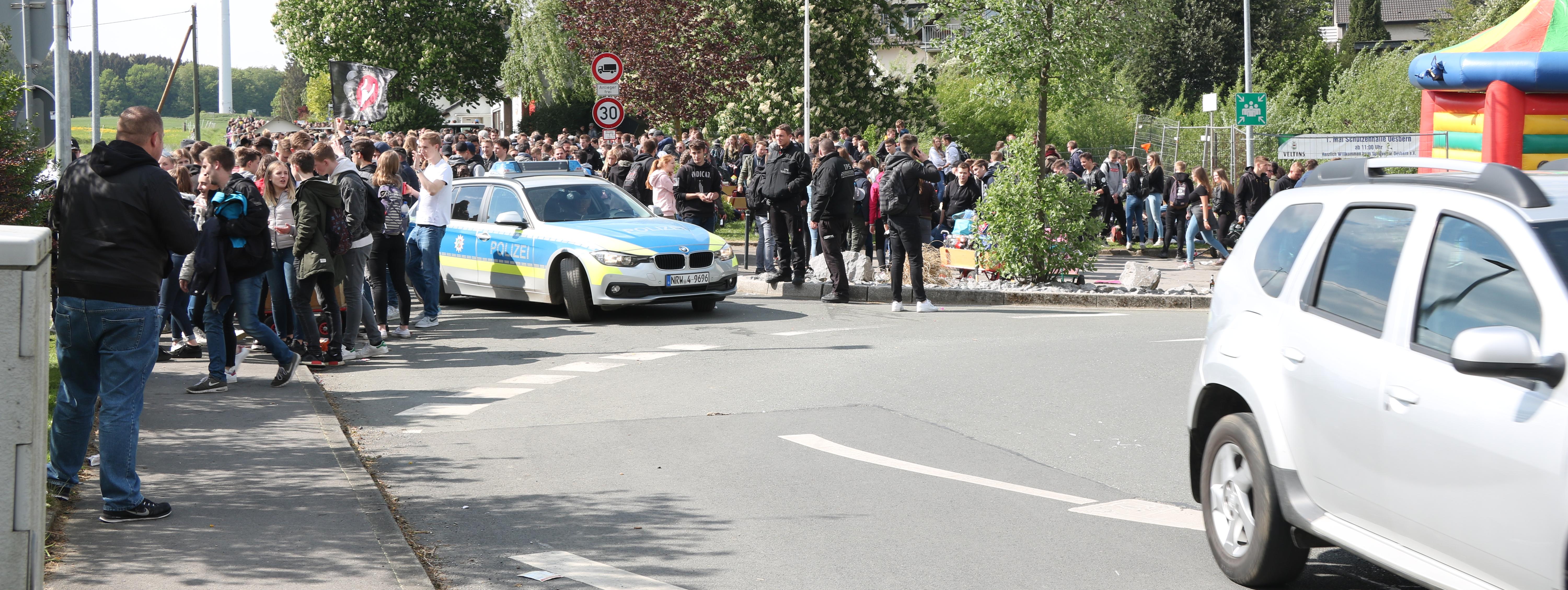 hunderte Jugendliche habe sich am Kreisverkehr in Oesbern versammelt und feiern den ersten Mai. In Mitten der Gruppe steht ein Polizeiauto.