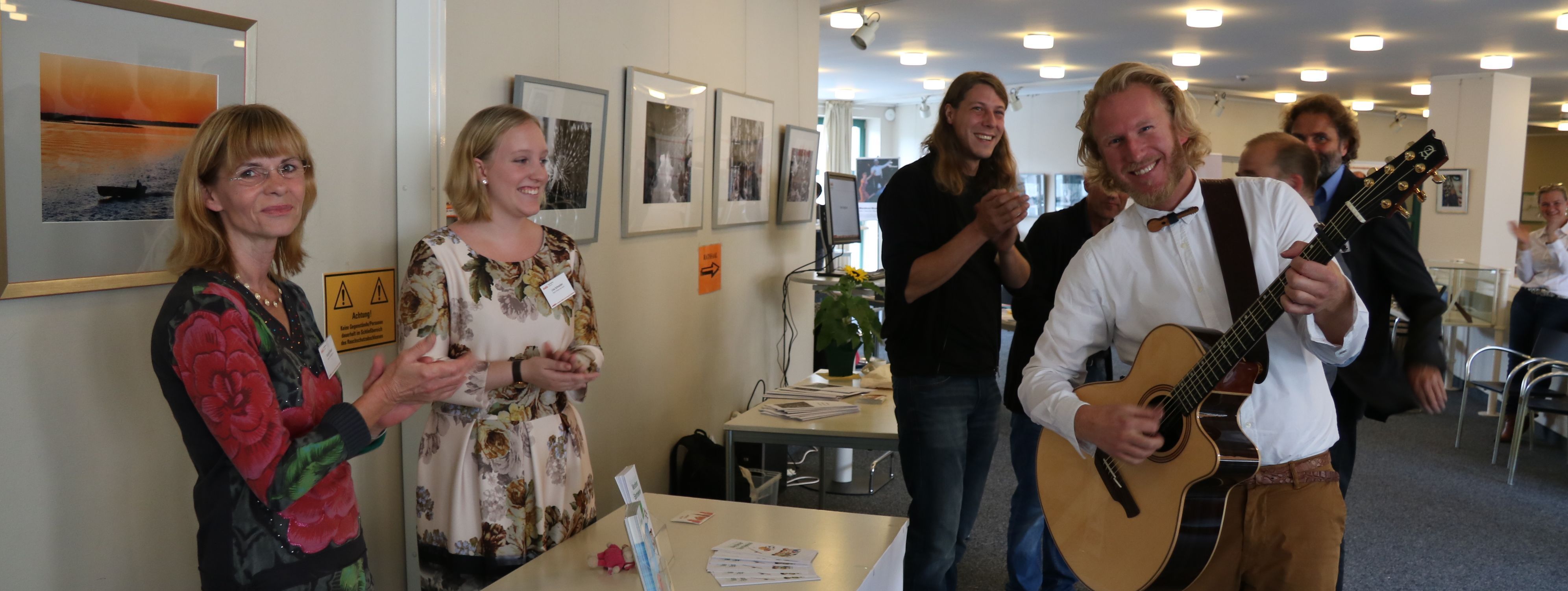 Der Künstler Phil_Solo steht mit seiner Gitarre vor dem Ratssaal beim Neubürgertag.