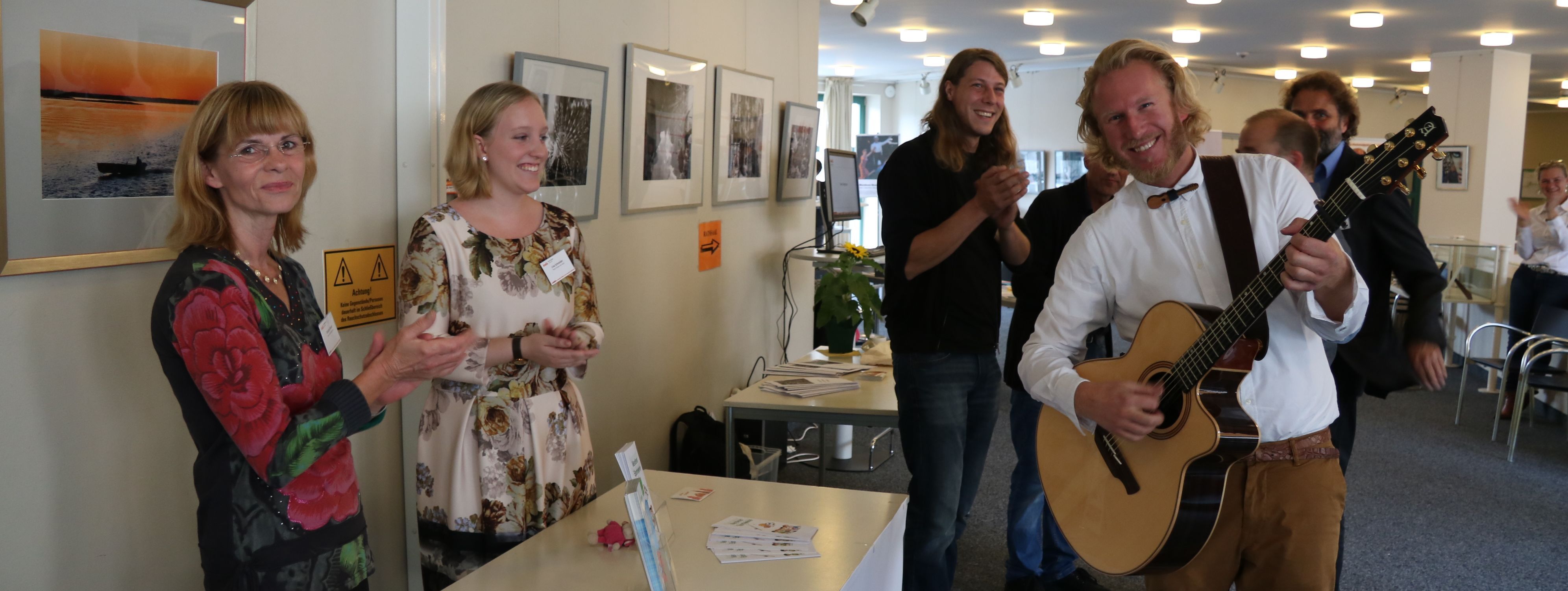 Der Künstler Phil_Solo steht mit seiner Gitarre vor dem Ratssaal beim Neubürgertag.