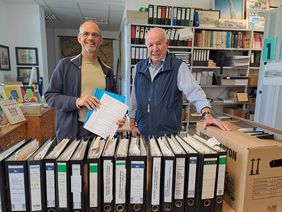 Stadtarchivar Stephan Reisloh und Elmar Dedirch stehen vor der Sammlung.