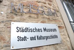 An der Außenwand des Stadtmuseums steht in großen Metallbuchstaben "Museum", darunter ist ein Metallschild mit der Aufschrift "Städtisches Museum für Stadt- und Kulturgeschichte