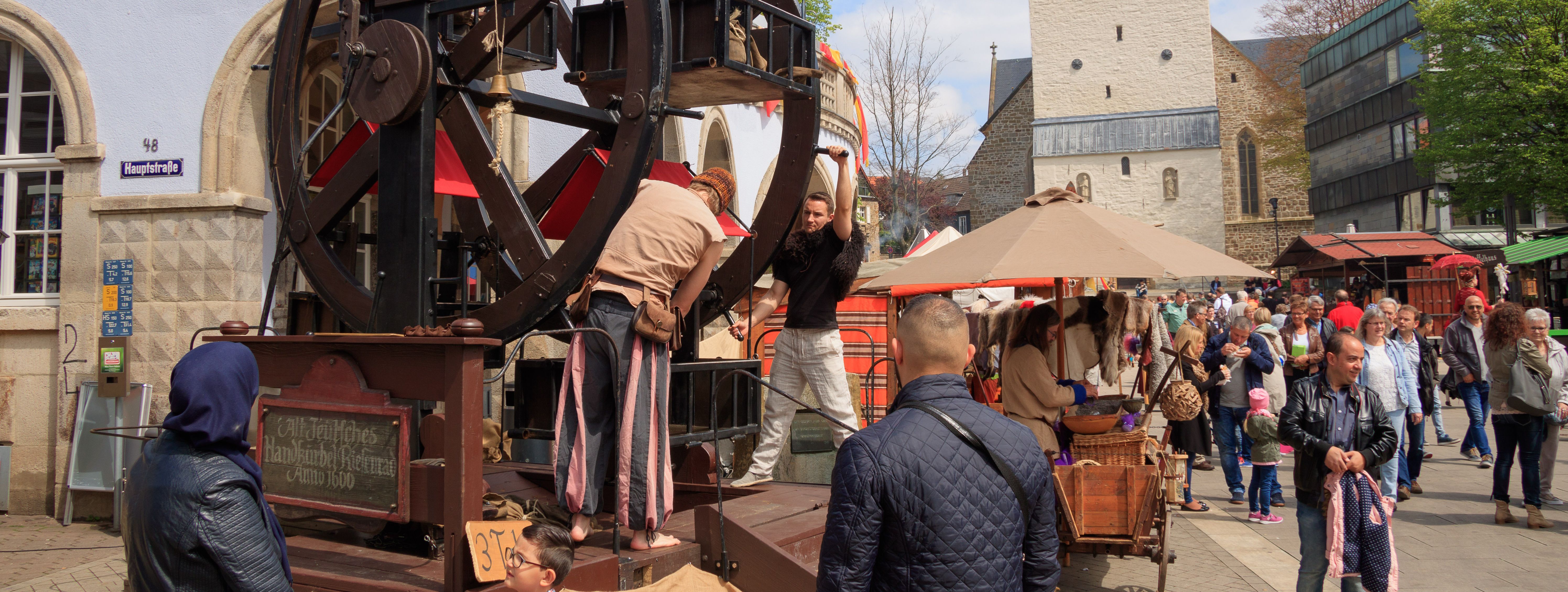 An der Ecke des Alten Rathauses steht ein Riesenrad aus Holz. Die Besonderheit ist, dass es von zwei Männern in mittelalterlichen Gewändern, per Hand gedreht wird. In den Gondeln, in denen keine Kinder sitzen, haben die Männer schwere Stoffsäcke platziert, damit dieses mittelalterliche Karussel auch gleichmäßig und rund läuft.