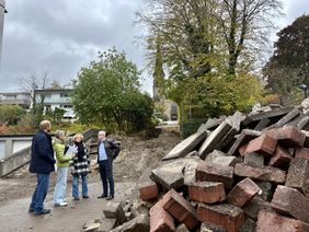 Baudezernent Tobias Wilms und Dagmar Gerling, Teamleiterin Bauen der Abteilung Straßenbau und Verkehr, zeigen Bürgermeister Dr. Roland Schröder und Manuela Schmidt die Pläne der jetzt beginnenden Baumaßnahme der Lebensader Lendringsen Mitte sowie die ersten Arbeiten am Treppenaufgangs zur Kirche St. Josef. (Foto: Vanessa Wittenburg/Stadt Menden).